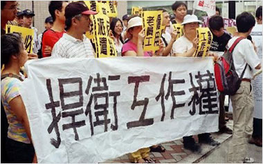 一抗议者头顶苹果笔记本，显示“负责”二字